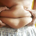 A Person Holding on to Belly Fat